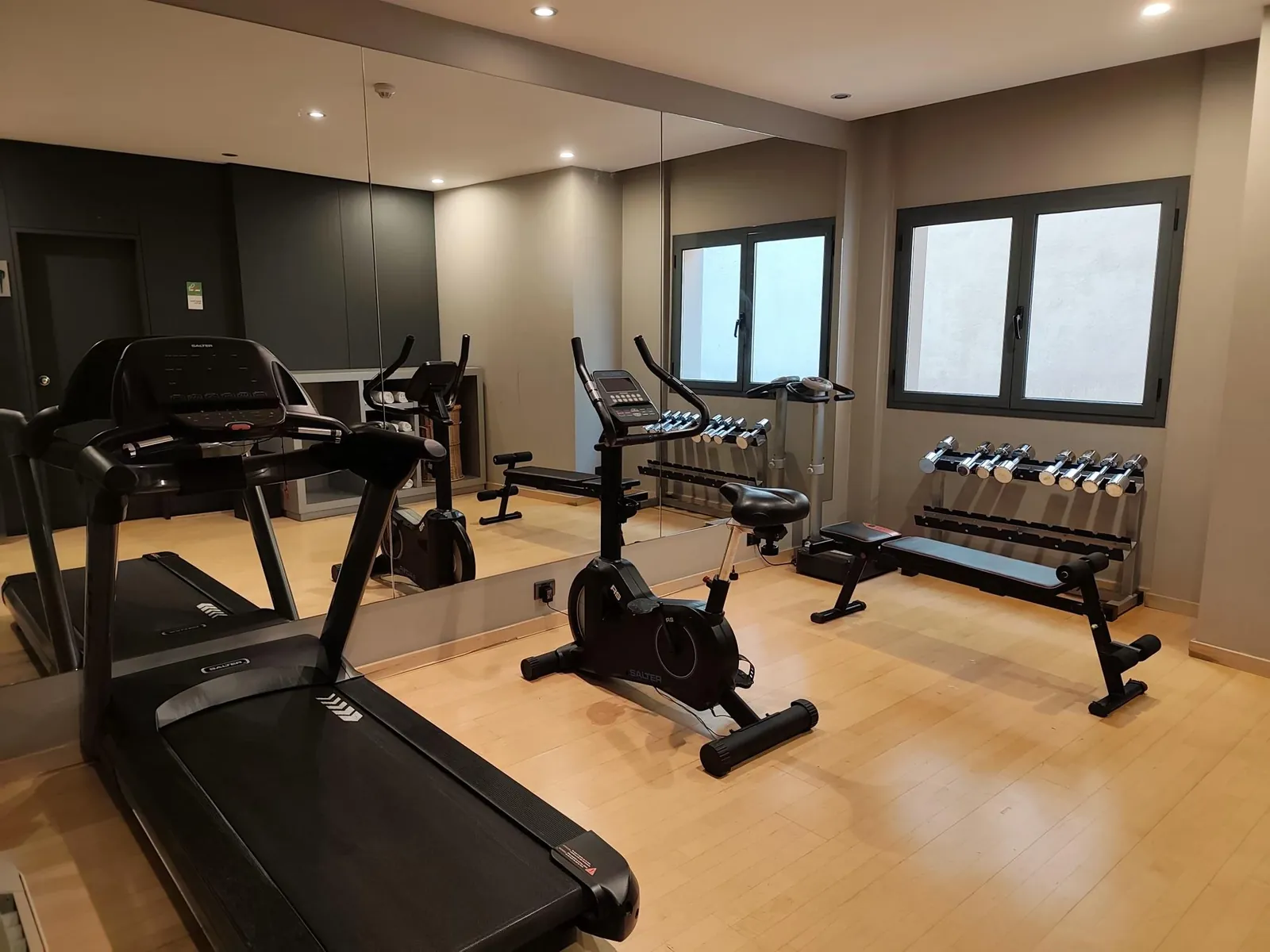 Sala de fitness con bicicleta estática, cinta de correr y toallas